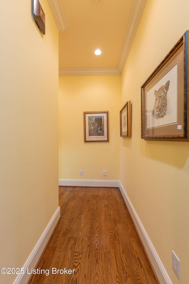 corridor with hardwood / wood-style flooring and ornamental molding