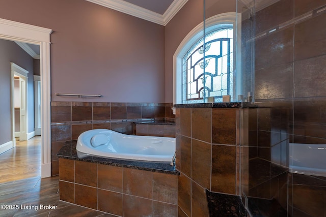 bathroom featuring hardwood / wood-style flooring, crown molding, and tiled bath