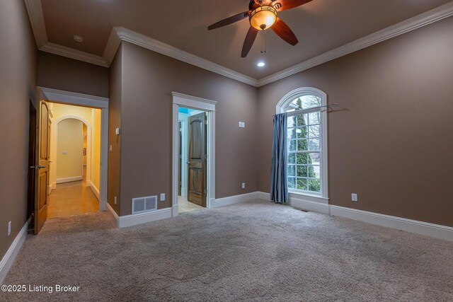 spare room featuring crown molding, light colored carpet, and ceiling fan