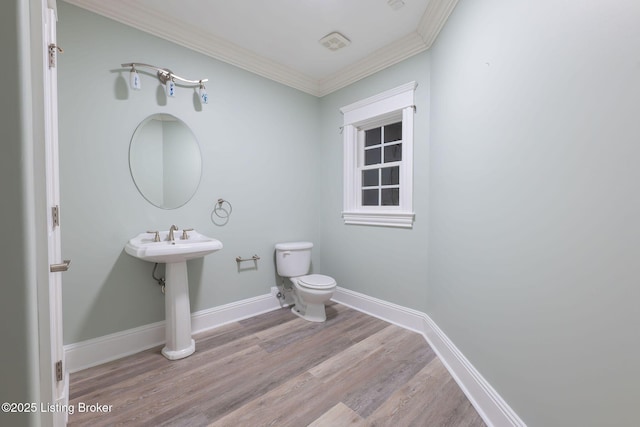 bathroom with ornamental molding, wood-type flooring, toilet, and sink