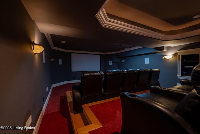 cinema with carpet floors, ornamental molding, and a raised ceiling