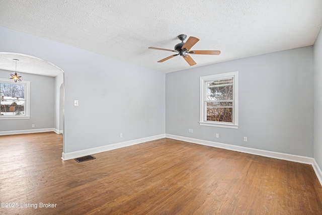 unfurnished room featuring hardwood / wood-style floors, a textured ceiling, a wealth of natural light, and ceiling fan