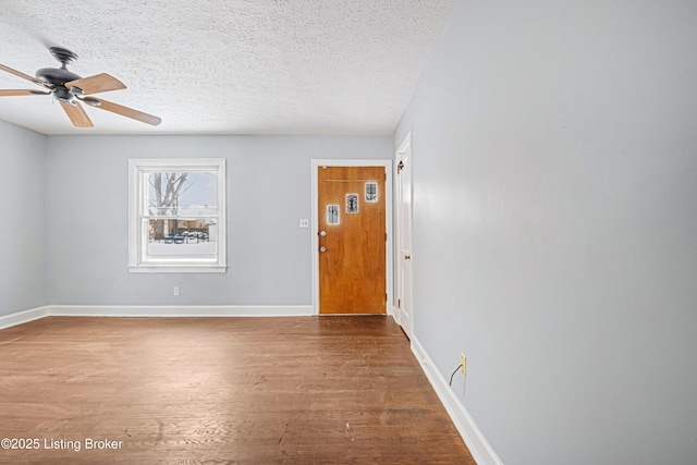 unfurnished room featuring hardwood / wood-style floors, ceiling fan, and a textured ceiling