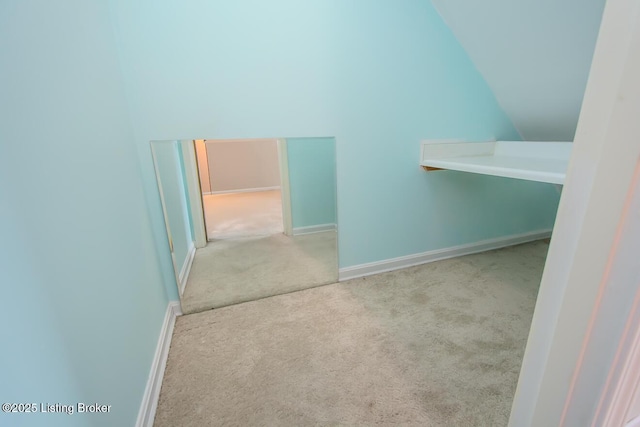 bonus room with light carpet and vaulted ceiling