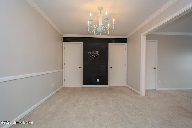 spare room featuring a chandelier, light colored carpet, and crown molding