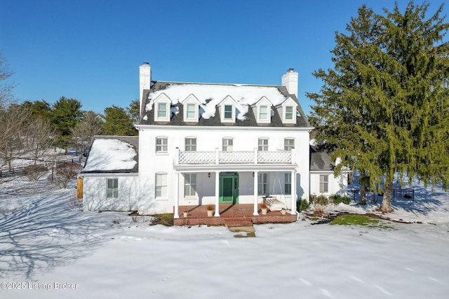 view of snow covered back of property