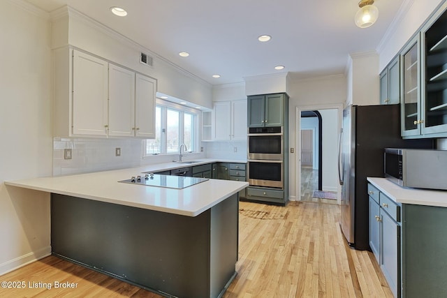 kitchen featuring appliances with stainless steel finishes, tasteful backsplash, and kitchen peninsula