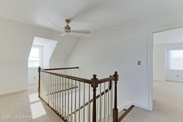 staircase with lofted ceiling, carpet flooring, ceiling fan, and ornamental molding