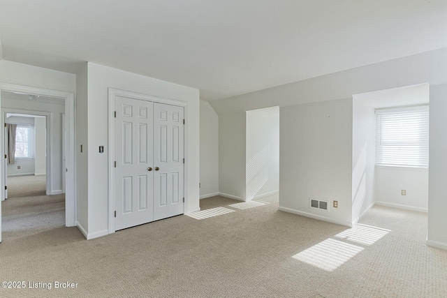 empty room with vaulted ceiling and light carpet