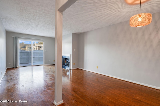 unfurnished living room featuring hardwood / wood-style floors and a textured ceiling