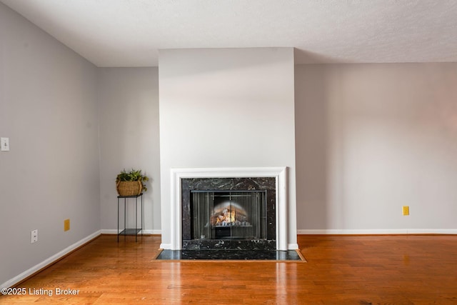 unfurnished living room featuring a high end fireplace and wood-type flooring