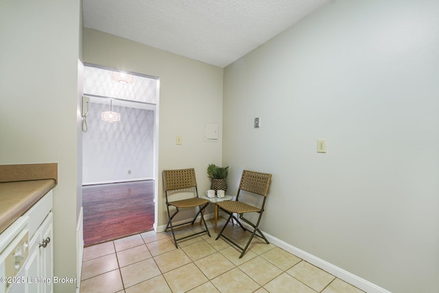 sitting room with a textured ceiling and light tile patterned floors