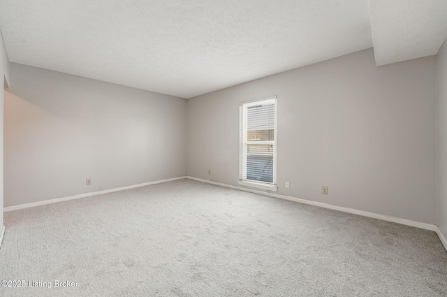 spare room with a textured ceiling and carpet