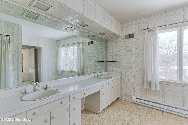 bathroom featuring baseboard heating and vanity