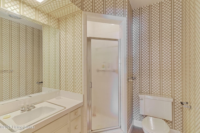 bathroom featuring vanity, toilet, and a shower with door