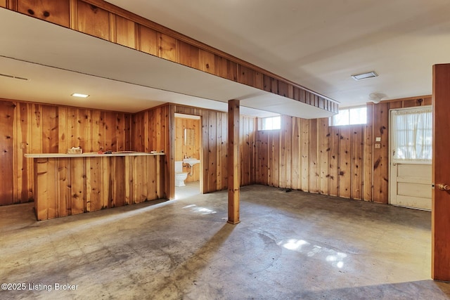 basement with bar area and wooden walls