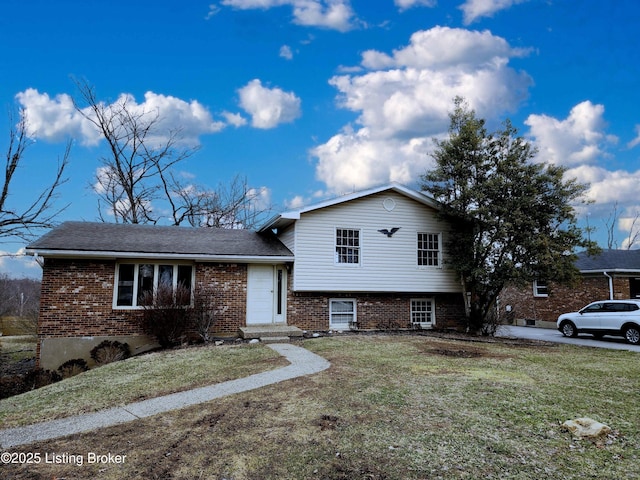 tri-level home featuring a front lawn and brick siding