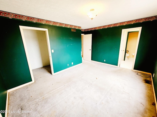 empty room featuring carpet and baseboards