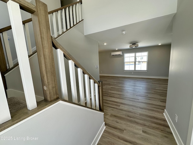 stairway featuring a wall mounted air conditioner and wood-type flooring