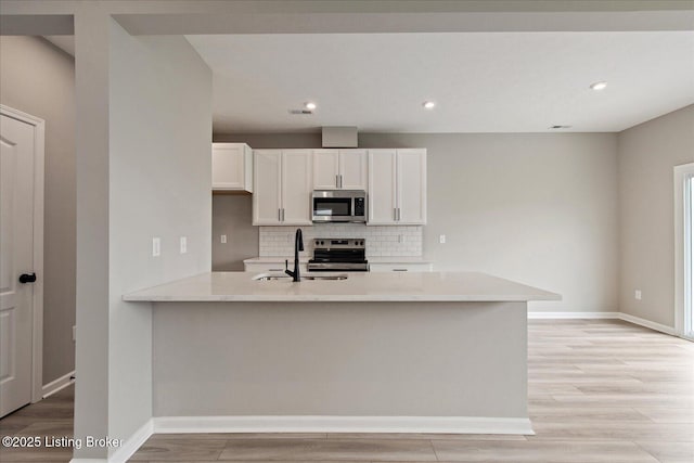 194 Harvest Point Way Unit 202B, Mt Washington, KY 40047 - kitchen featuring appliances with stainless steel finishes, decorative backsplash, light wood-style floors, white cabinets, and recessed lighting