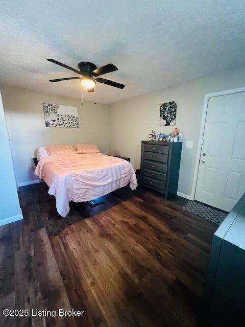 bedroom featuring ceiling fan, dark wood-type flooring, and a textured ceiling