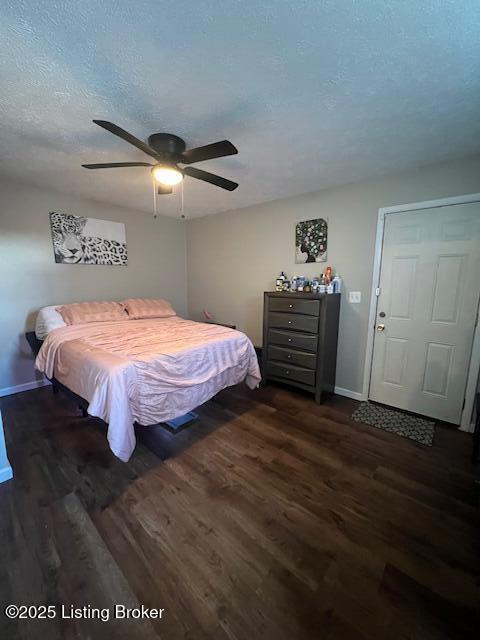 bedroom featuring a textured ceiling, dark hardwood / wood-style floors, and ceiling fan