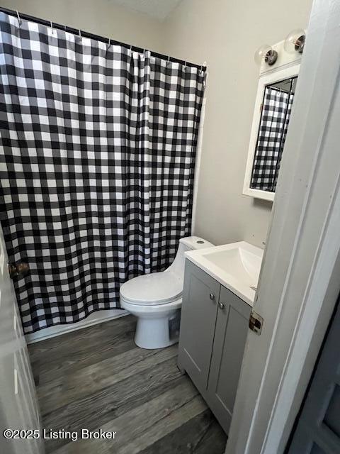 bathroom featuring vanity, hardwood / wood-style flooring, and toilet