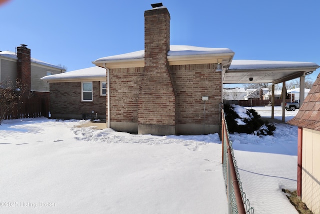 view of snow covered rear of property