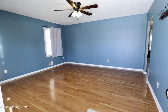 spare room featuring a textured ceiling, ceiling fan, and hardwood / wood-style flooring