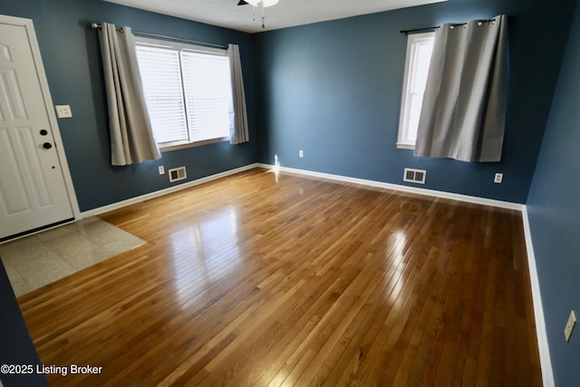 unfurnished room with hardwood / wood-style flooring, ceiling fan, and a wealth of natural light