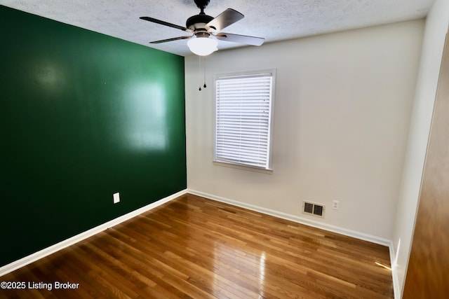 spare room featuring a textured ceiling, ceiling fan, and hardwood / wood-style floors