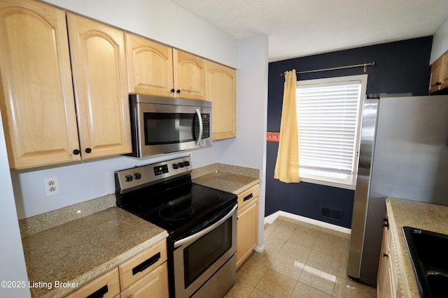 kitchen featuring sink, stainless steel appliances, and light brown cabinetry