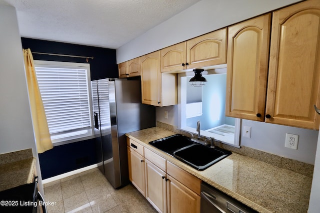 kitchen featuring sink, light brown cabinetry, a textured ceiling, and stainless steel refrigerator with ice dispenser