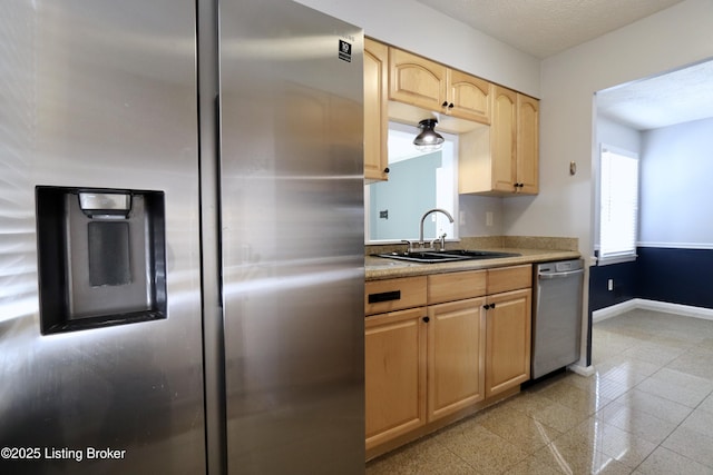 kitchen featuring appliances with stainless steel finishes, sink, and light brown cabinets