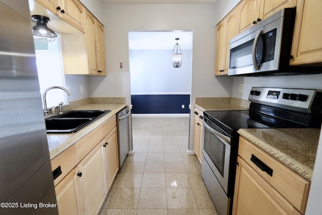 kitchen with sink, light brown cabinets, decorative light fixtures, and appliances with stainless steel finishes