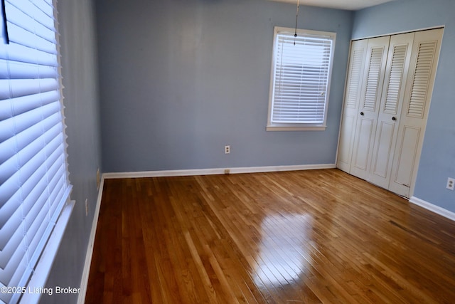 unfurnished bedroom with a closet and hardwood / wood-style floors