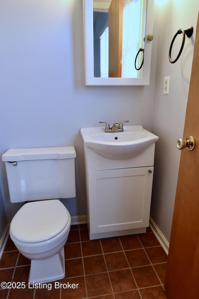 bathroom with toilet, tile patterned flooring, and vanity