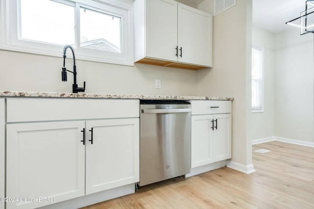 kitchen featuring sink, light stone counters, light hardwood / wood-style flooring, stainless steel dishwasher, and white cabinets