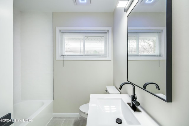 full bathroom featuring tile patterned flooring, bathtub / shower combination, toilet, and sink