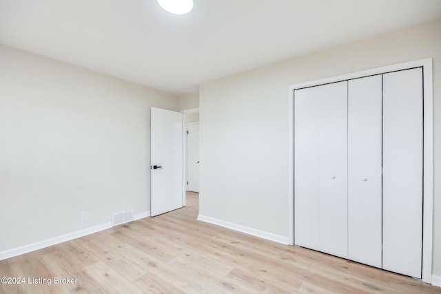 unfurnished bedroom featuring a closet and light hardwood / wood-style floors