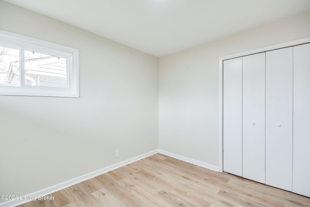 unfurnished bedroom with light hardwood / wood-style floors and a closet