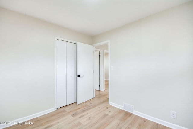 unfurnished bedroom with light hardwood / wood-style floors and a closet