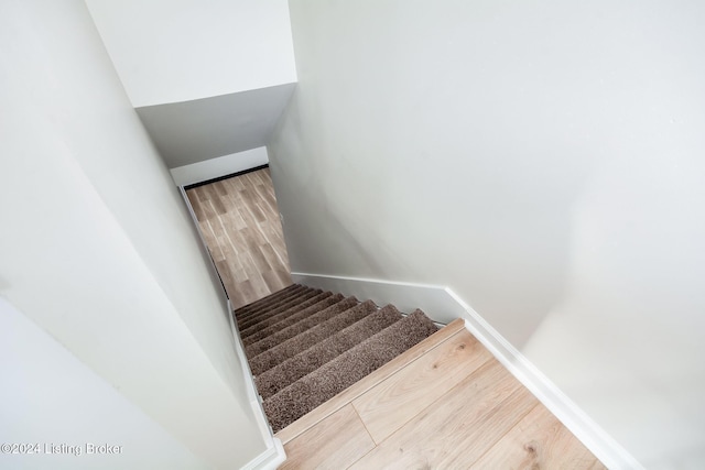 staircase with hardwood / wood-style floors