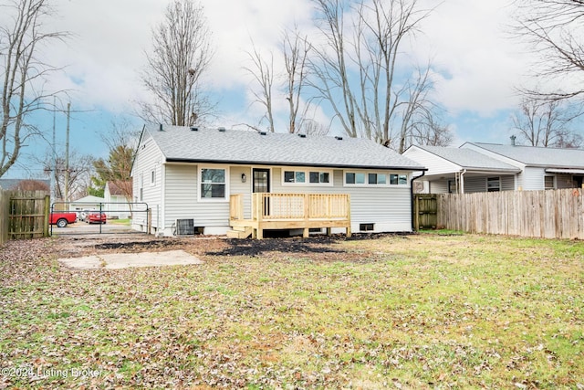 rear view of house with a yard and a wooden deck