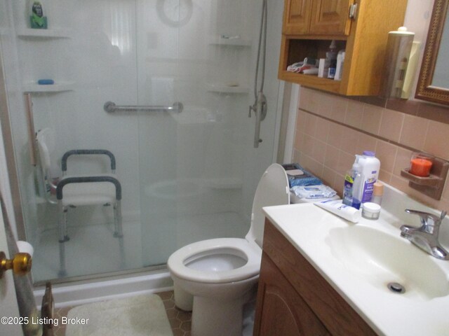 bathroom featuring decorative backsplash, toilet, an enclosed shower, and vanity