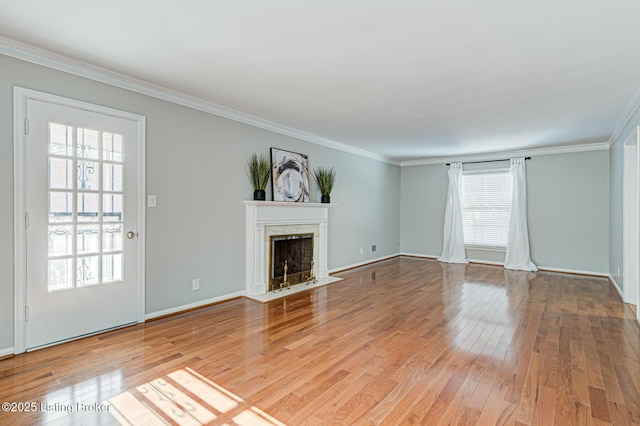 unfurnished living room with ornamental molding, a healthy amount of sunlight, and light hardwood / wood-style flooring