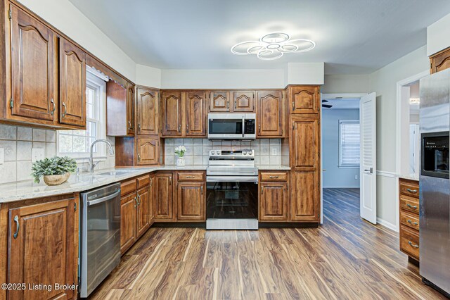 kitchen featuring dark wood-type flooring, stainless steel appliances, decorative backsplash, and sink