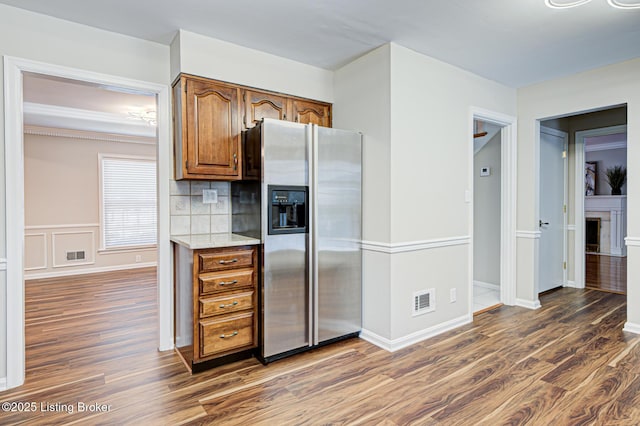 kitchen featuring dark wood-type flooring, backsplash, and stainless steel fridge