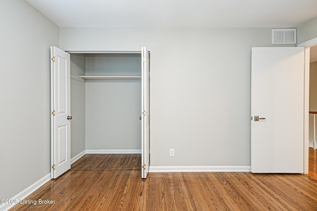 unfurnished bedroom featuring a closet and wood-type flooring