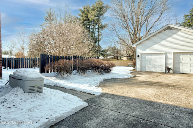 yard layered in snow featuring a garage